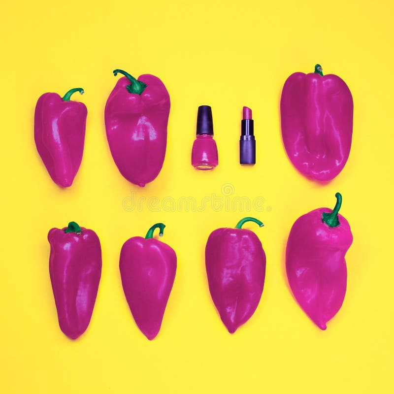Smalto e rossetto rossi, fra tantissimi peperoni su fondo giallo immagini stock Smalto e rossetto rossi, fra tantissimi peperoni su fondo giallo immagini stock