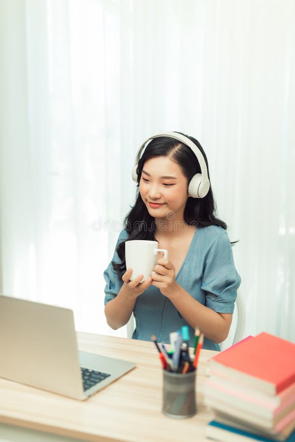 Smart asian  girl desk work remote laptop watch seminar drink beverage mug in house indoors