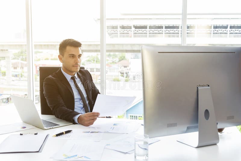 Smart businessman working with paper work report and computer in office. Modern technology for work royalty free stock photography Smart businessman working with paper work report and computer in office. Modern technology for work royalty free stock photography
