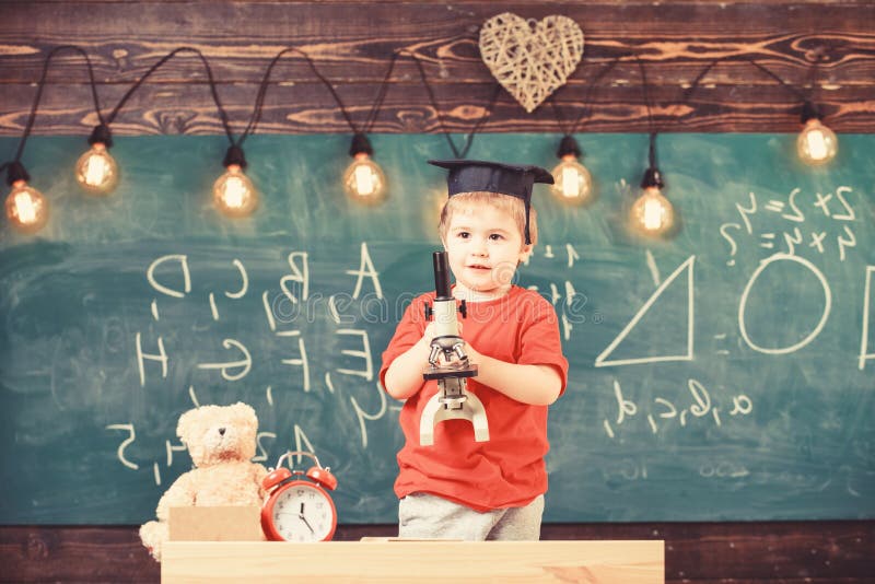 Smart kid concept. First former interested in studying, learning, education. Child on happy face holds microscope. Kid royalty free stock photo
