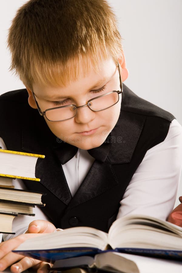 Smart looking school boy reading a book