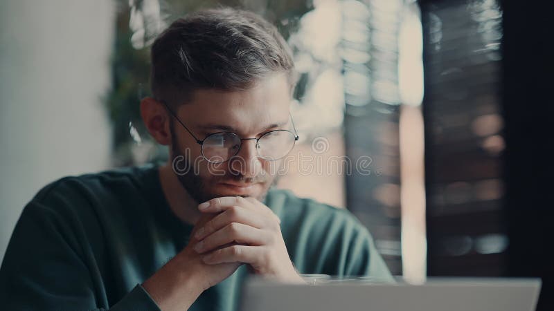 Smart Man läser nyheter på webbplatsen och tittar på skärmen på den bärbara datorn i Cafe lager videofilmer