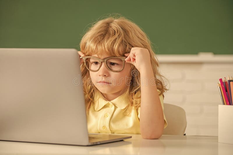 Smart Nerd Kid in Glasses with Laptop. September 1. Elearning. Child Studying on Computer Stock