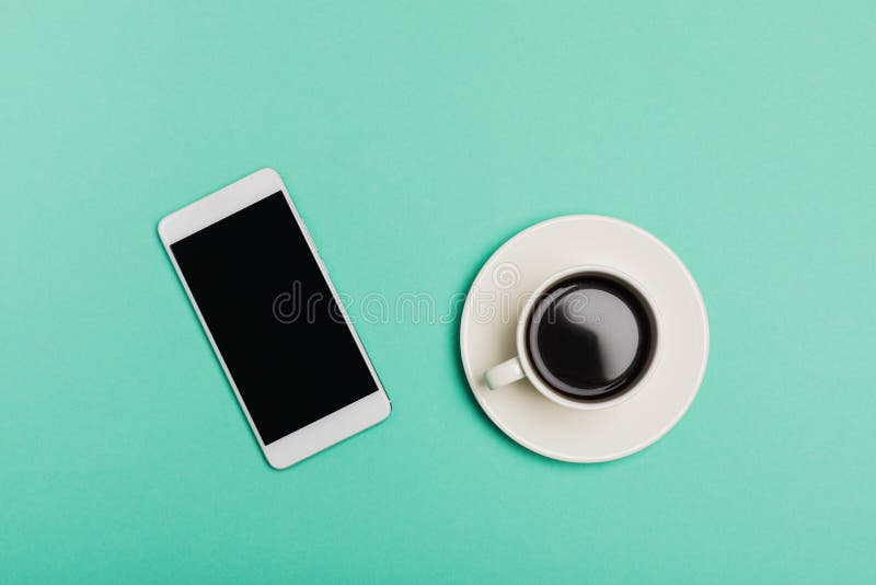 Smart Phone e tazza di caffè sullo scrittorio blu, vista superiore, disposizione piana immagini stock libere da diritti Smart Phone e tazza di caffè sullo scrittorio blu, vista superiore, disposizione piana immagini stock libere da diritti