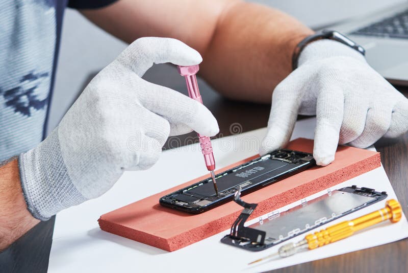 Smart Phone Repair. Repairman Hands with Screwdriver Stock Photo
