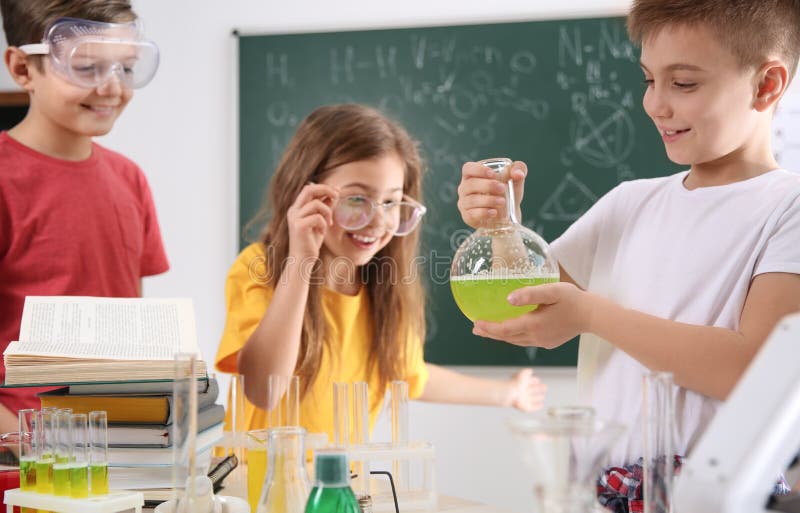 Smart pupils making experiment in class stock photography