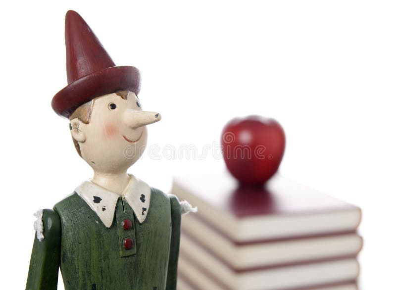 Puppet with apple on pile of books. Little marionette stock images, royalty-free photos and pictures