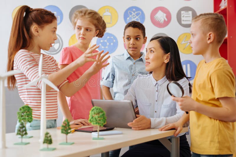 Smart schoolchildren sharing their ecology project idea with teacher