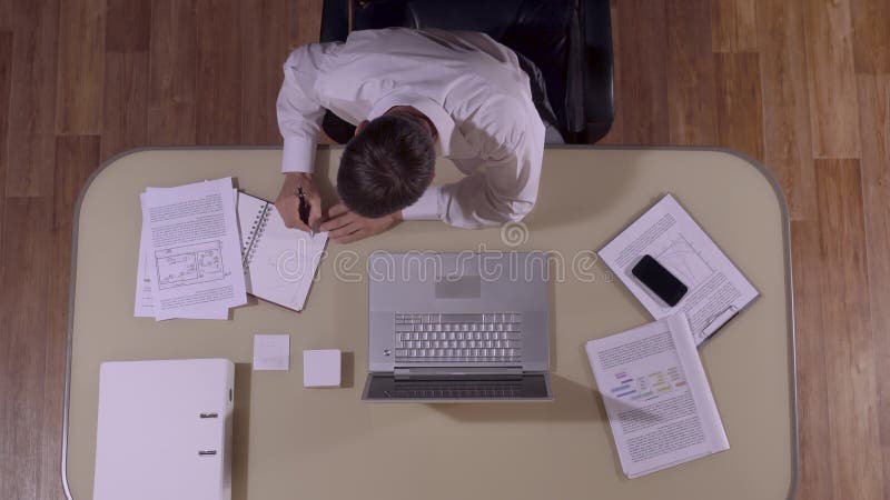 Smart-se affärsmansammanträde på hans tabell och arbete arkivfilmer