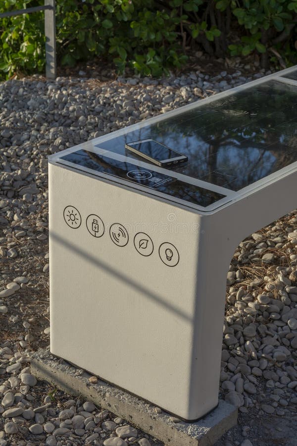 Smart Solar Bench in public place, powered by sunlight provides wireless and wired charging for users, free wifi and temperature stock images