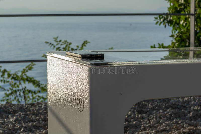 Smart Solar Bench in public place, powered by sunlight provides wireless and wired charging for users, free wifi and temperature royalty free stock photos.