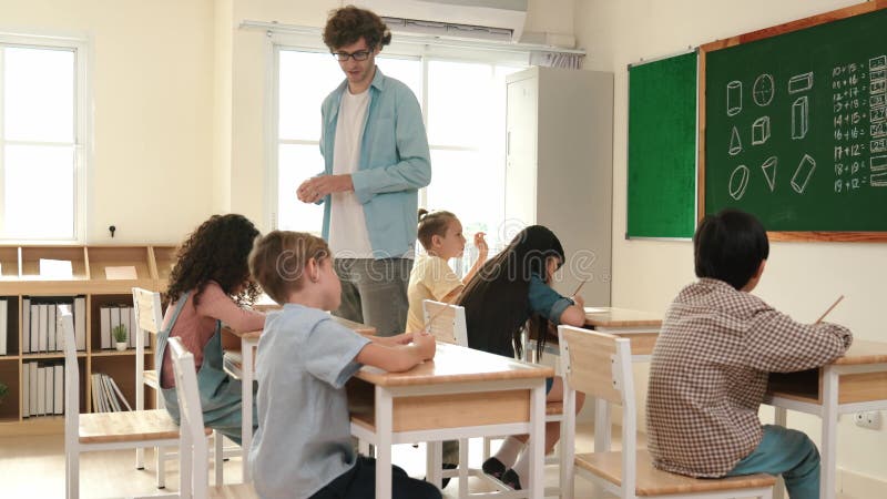 Smart teacher walking at classroom while looking at student homework. Pedagogy. stock video footage