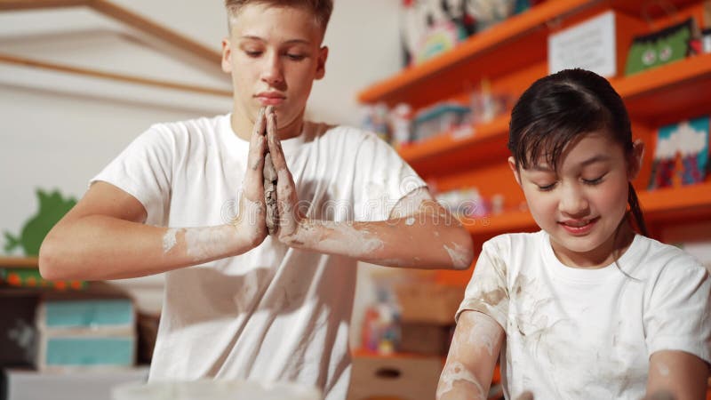 Smart teenager modeling cup of clay while laughing at art lesson. Edification stock video footage