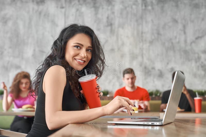 Smart woman drinking water while working online in cafe stock photos Smart woman drinking water while working online in cafe stock photos