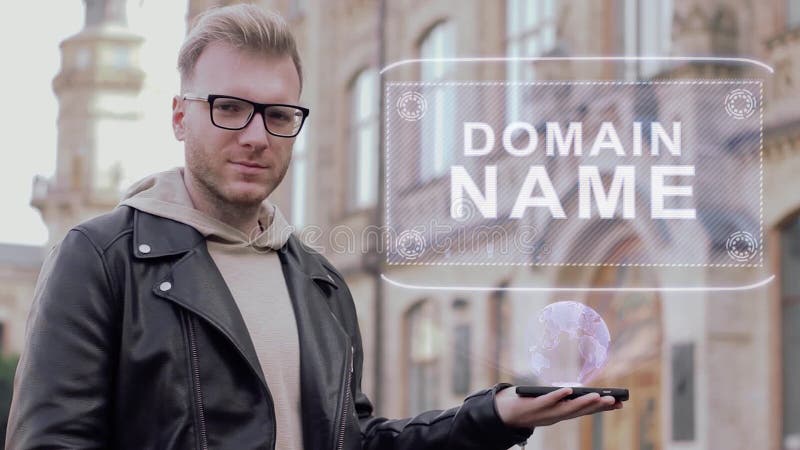 Smart young man with glasses shows a conceptual hologram Domain name