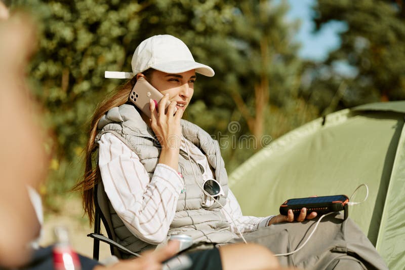 Γυναίκα που μιλάει στο smartphone ενώ φορτίζει τη συσκευή σε κατάληψη στοκ εικόνα με δικαίωμα ελεύθερης χρήσης