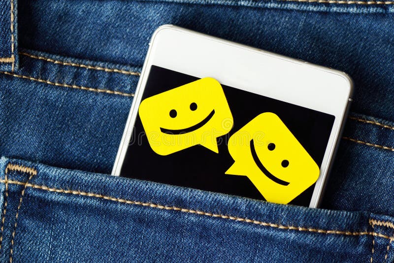 Smartphone dans des jeans empochent avec des bulles de message de causerie image libre de droits