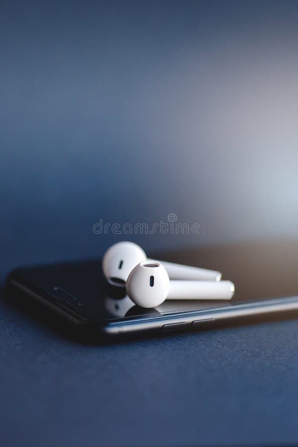 Smartphone e cuffie wireless isolati sullo sfondo grigio fotografie stock