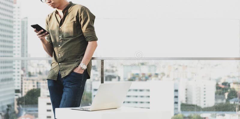 Smartphone en laptop van het jonge mensengebruik in middag, technologie lif royalty-vrije stock afbeeldingen Smartphone en laptop van het jonge mensengebruik in middag, technologie lif royalty-vrije stock afbeeldingen