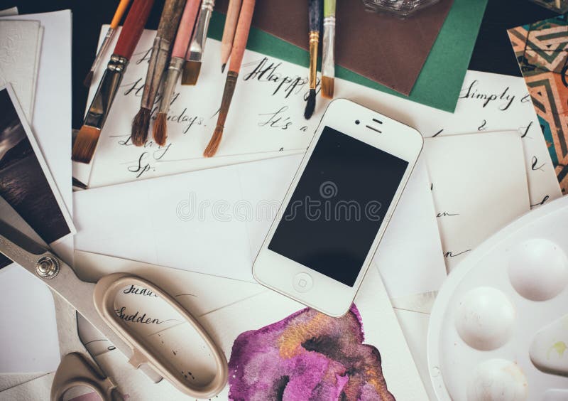 Smartphone en una tabla en el estudio del artista fotos de archivo Smartphone en una tabla en el estudio del artista fotos de archivo