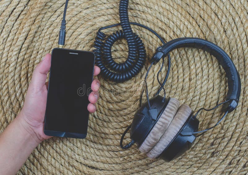 Smartphone headphonemusik på en juterepbakgrund royaltyfri fotografi
