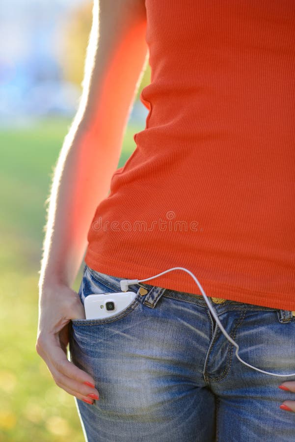 Smartphone with Headphones in Pocket of Woman Jeans stock image