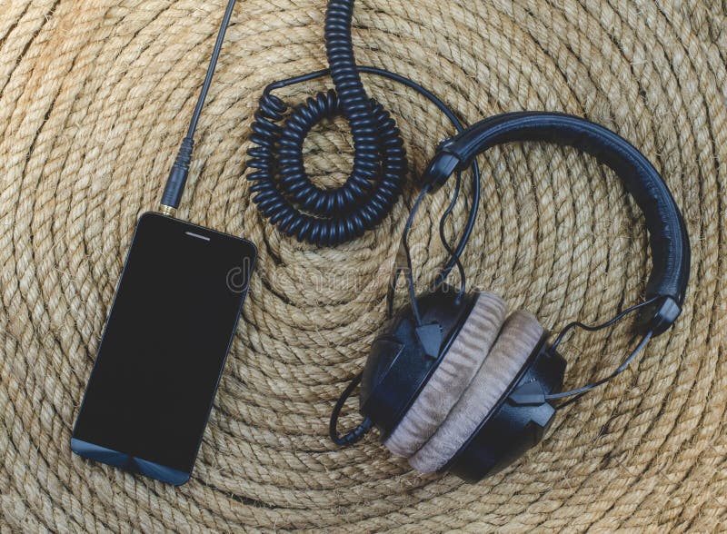 Smartphone och headphonemusik på en repbakgrund royaltyfria foton