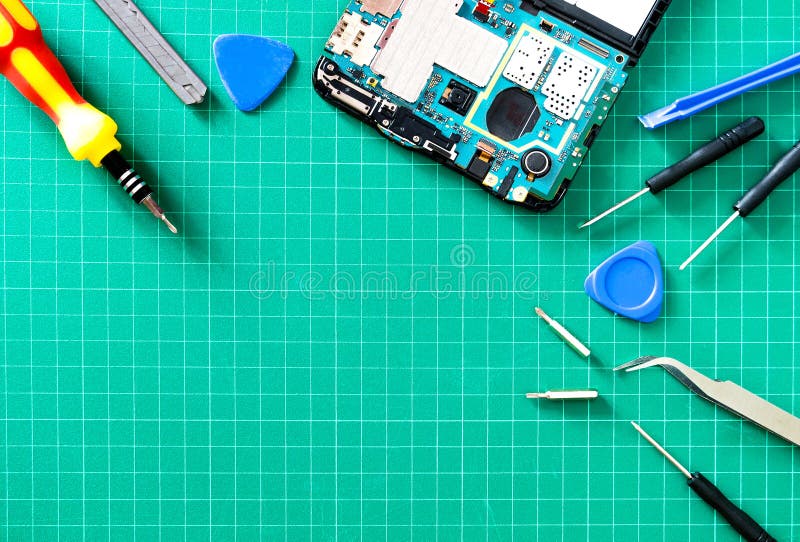 Smartphone`s motherboard and tools lay on the green table, concept of computer hardware, mobile phone, electronic, repairing royalty free stock images