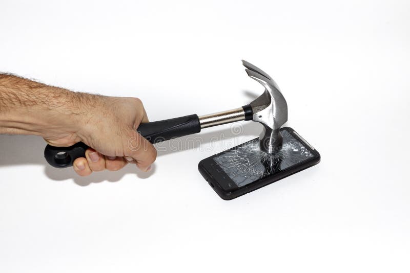 Male hand smashing a smartphone screen with a hammer. Could be used to demonstrate a need to get away from todays always connected world. Male hand smashing a smartphone screen with a hammer. Could be used to demonstrate a need to get away from todays always connected world