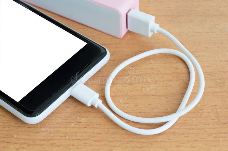Smartphone z różowym powerbank na drewnianym biurku zdjęcia stock Smartphone z różowym powerbank na drewnianym biurku zdjęcia stock