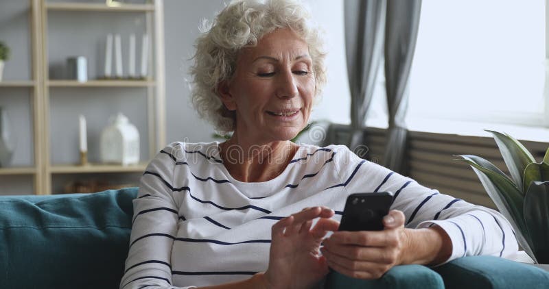 Smartphone âgé moyen heureux de participation de femme en utilisant des applications mobiles. banque de vidéos