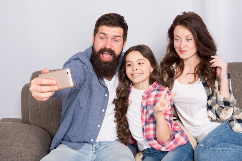 Smartphone χρήσης για το selfie Φιλική οικογένεια που έχει τη διασκέδαση από κοινού Χαλάρωση μπαμπάδων και κορών Mom στον καναπέ στοκ εικόνες Smartphone χρήσης για το selfie Φιλική οικογένεια που έχει τη διασκέδαση από κοινού Χαλάρωση μπαμπάδων και κορών Mom στον καναπέ στοκ εικόνες