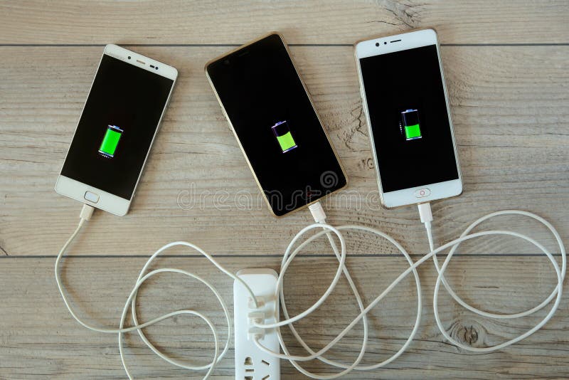 Smartphones wordt geladen van de lader en ligt zij aan zij royalty-vrije stock foto Smartphones wordt geladen van de lader en ligt zij aan zij royalty-vrije stock foto