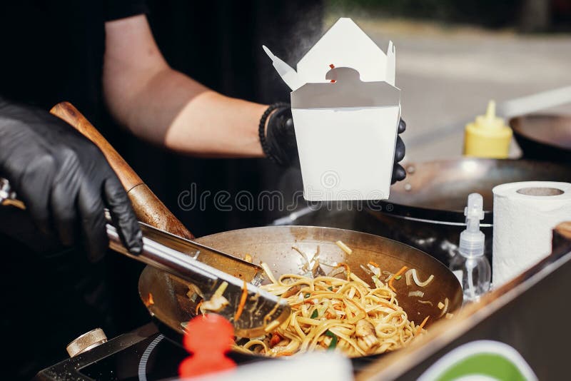 Smażący chińscy japońscy kluski z warzywami i garnelami w takeaway boksują Karmowa dostawa Szefa kuchni kładzenia kluski w karton zdjęcia royalty free Smażący chińscy japońscy kluski z warzywami i garnelami w takeaway boksują Karmowa dostawa Szefa kuchni kładzenia kluski w karton zdjęcia royalty free