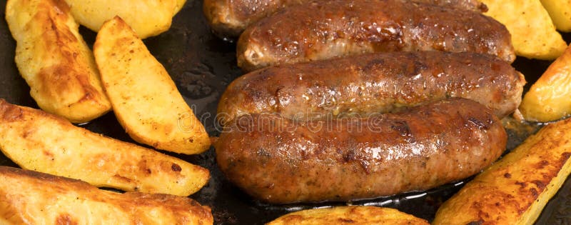 Smażone kiełbasy i ziemniaki selektywne miękkie fokus szeroki obraz fotografia royalty free