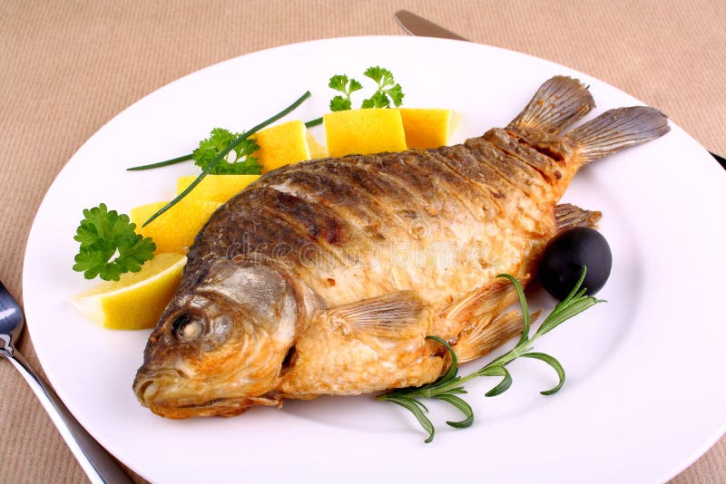 Smażący karp na bielu talerzu z nożem i rozwidleniem obrazy royalty free Smażący karp na bielu talerzu z nożem i rozwidleniem obrazy royalty free