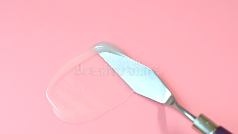 Smear of moisturizer on pink background close-up.