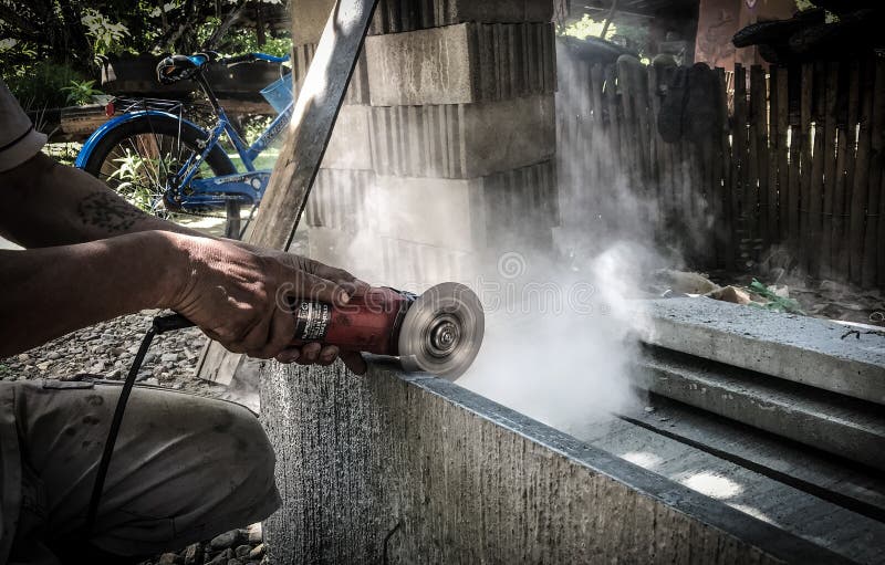 Smerigliatore a angolo d’inclinazione acciaio di taglio. un operaio che taglia acciaio in lamiera di calcestruzzo con trituratore. immagini stock libere da diritti