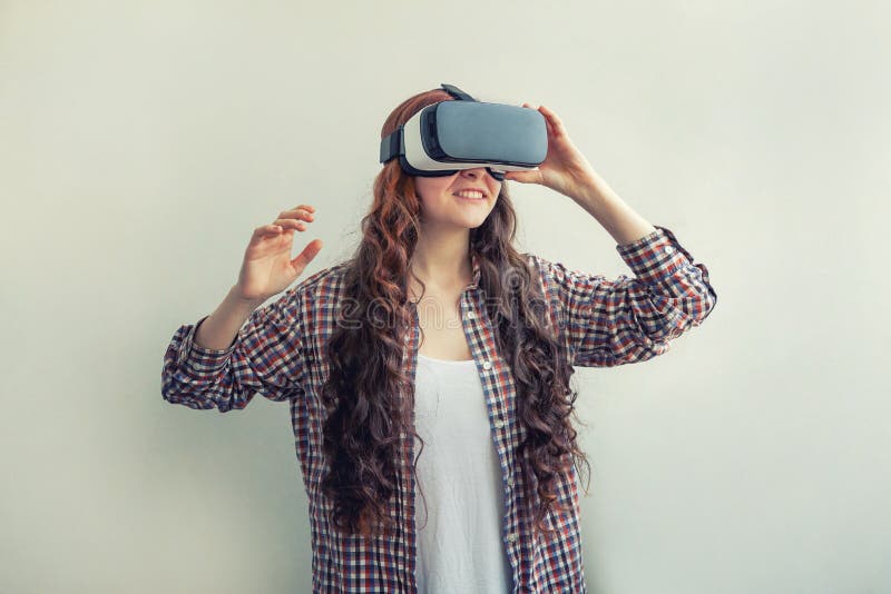 Smila unga kvinnor som använder virtuell verklighet VR-glasögon helmet headset på vit bakgrund Smartphone använda med royaltyfri fotografi Smila unga kvinnor som använder virtuell verklighet VR-glasögon helmet headset på vit bakgrund Smartphone använda med royaltyfri fotografi