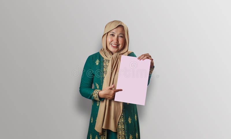 Smilda muslimska kvinnor som pekar på rosa papper i traditionell konfektion royaltyfria bilder