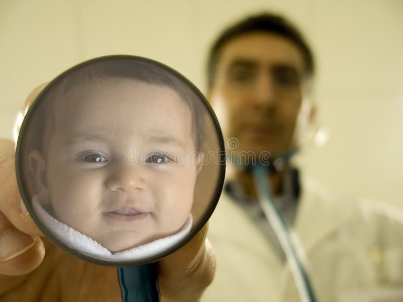 Medico con lo stetoscopio in cui si riflette il volto di un sorriso di bambina.