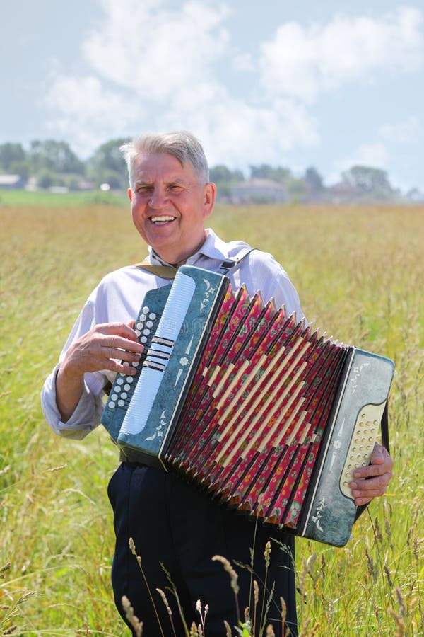 Smile grandfather plays on accordion