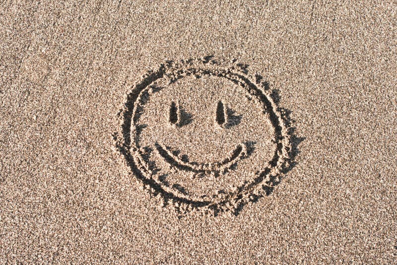 Smiley face drawn on beach sand