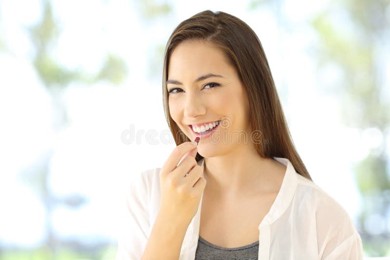 Portrait of a smiley woman taking a pill looking at you. Portrait of a smiley woman taking a pill looking at you