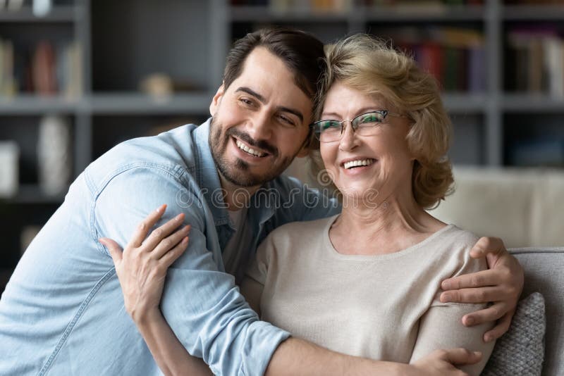 Smiling adult son and senior mother visualize looking in distance