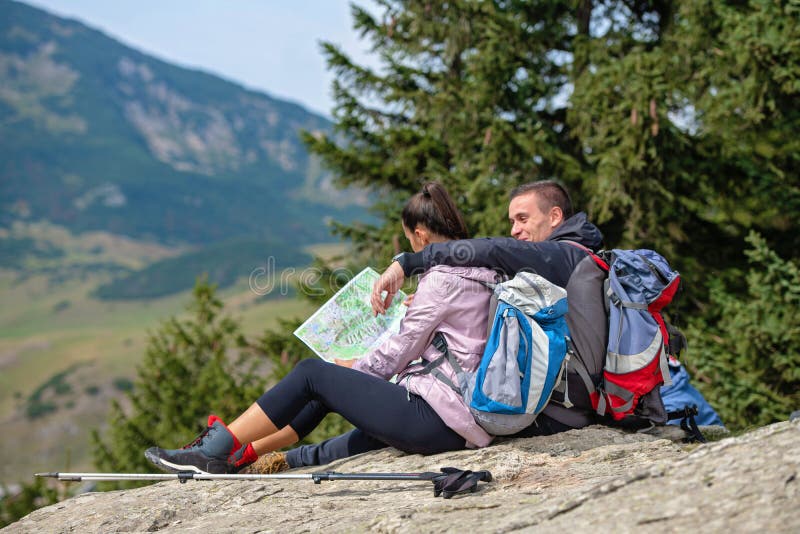 Smiling adventure couple with map on slope. look at map royalty free stock photo Smiling adventure couple with map on slope. look at map royalty free stock photo