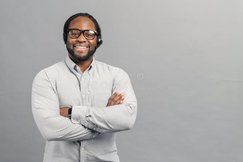 Smiling African-American man wearing headset isolated on grey