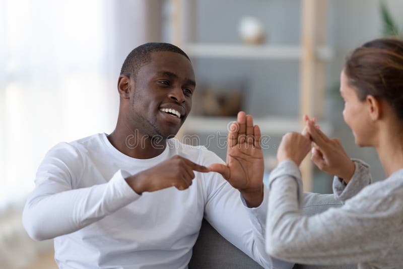 Smiling African American man and woman speaking sign language