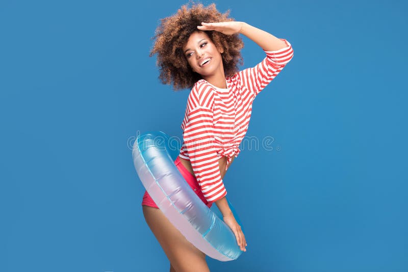 Smiling afro woman in sailor style shirt.