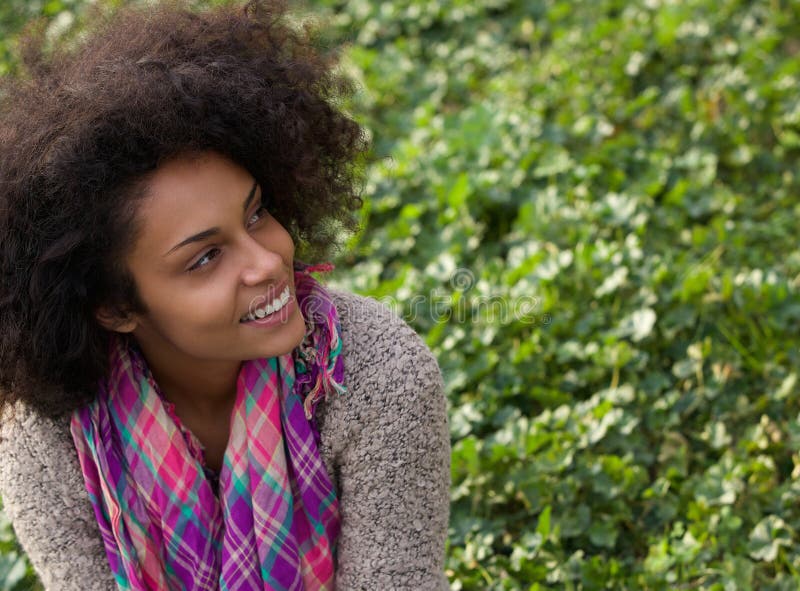 Smiling african american woman sitting on grass